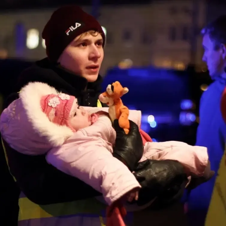 Young man holding a baby.